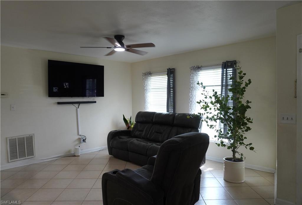 Image 3: Living area with ceiling fan and light tile patterned floors