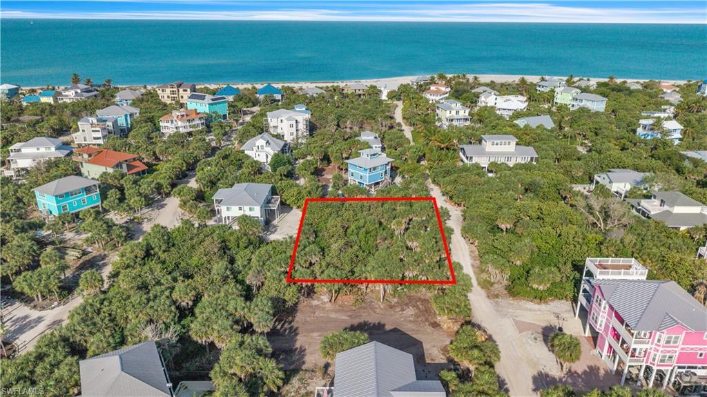 Image 2: Aerial view of 4521 Oro Pesos Lane (outlined in red) &mdash; nestled among established island homes on North Captiva, with the Gulf of Mexico visible just steps away.