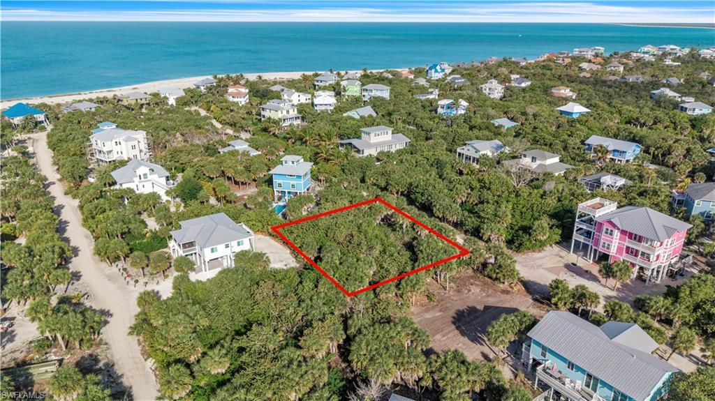 Image 4: Aerial view of 4521 Oro Pesos Lane (outlined in red) &mdash; nestled among established island homes on North Captiva, with the Gulf of Mexico visible just steps away.