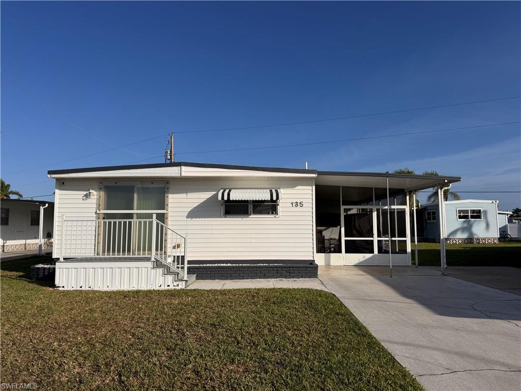Image 1: Front of home, slider featured with hurricane protection cover.  Ample Parking