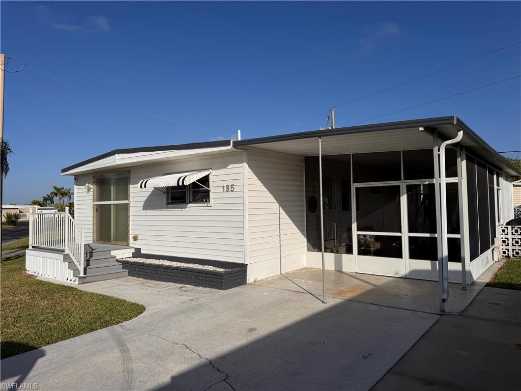 Image 2: Angle photo of home, showing great parking and double-door entry to screen room.