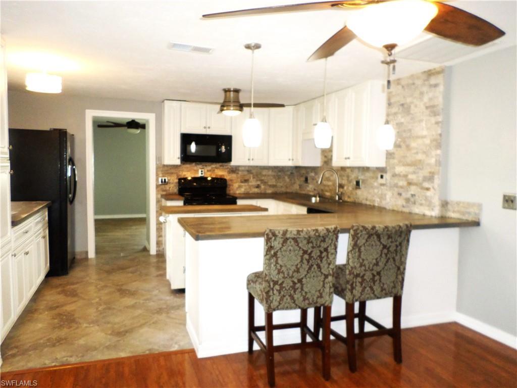 Image 4: Large Open Kitchen With Island & 2 Bar Stools.