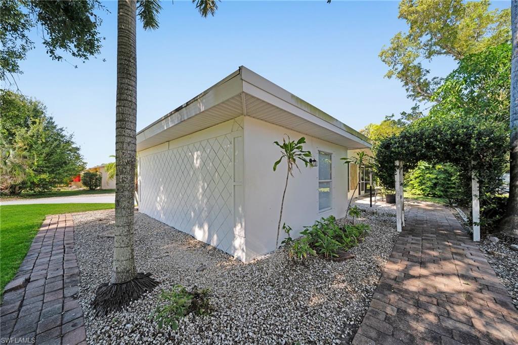 Image 3: White stucco exterior featuring a decorative lattice panel and a flat roofline