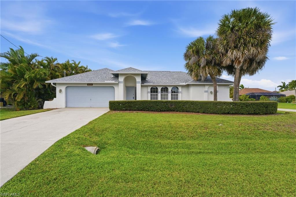 Image 1: Exterior residence featuring an arched portico entry and a two-car garage