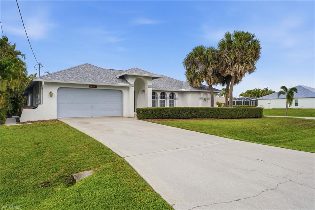 Image 2: White stucco exterior with a gray shingle roof and an attached garage