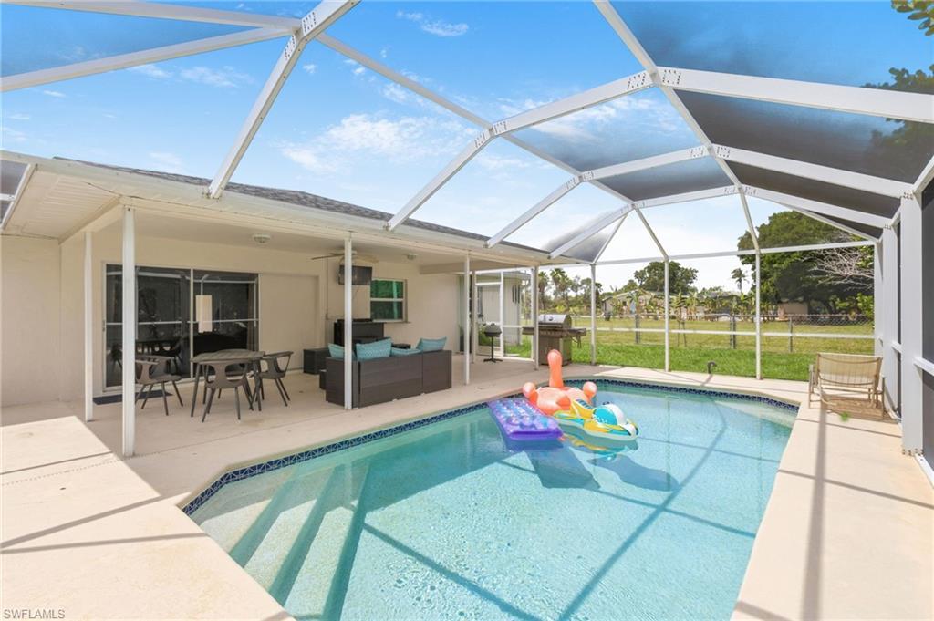 Image 4: Screened-in pool area featuring a concrete deck, tiled pool, and a covered patio with sliding glass doors