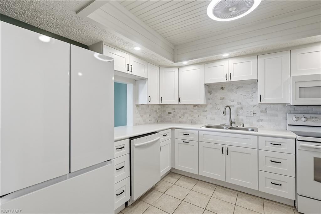 Image 3: Updated kitchen features sleek appliances, all new soft-close cabinets with multiple drawers and pass through to dining.