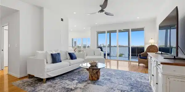 Image 4: Elegant wood flooring flows throughout the residence, while a dramatic wall of sliding glass doors frames breathtaking, panoramic views of Estero Bay.