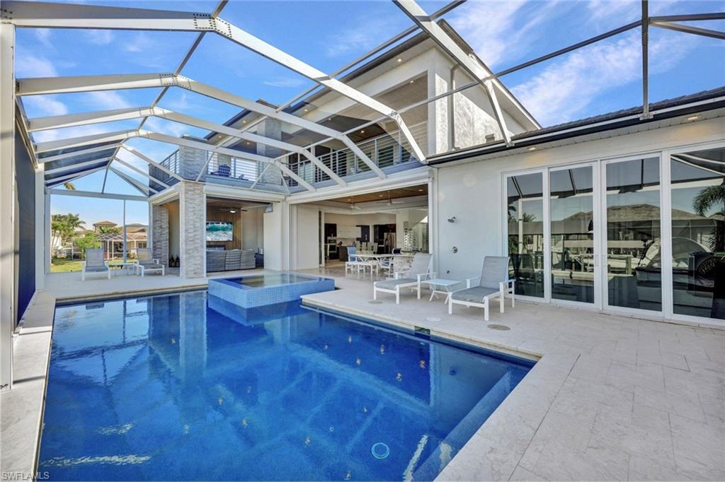 Image 1: Oversized heated pool/spa area with 1/2 bath & outdoor kitchen