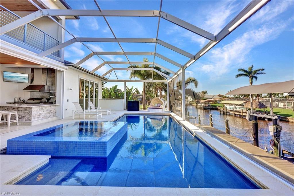 Image 4: Large heated pool with an integrated spa & an outdoor kitchen