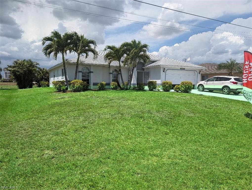 Image 2: Single-story residence featuring a two-car garage, established front landscaping, palm trees, and a spacious front lawn