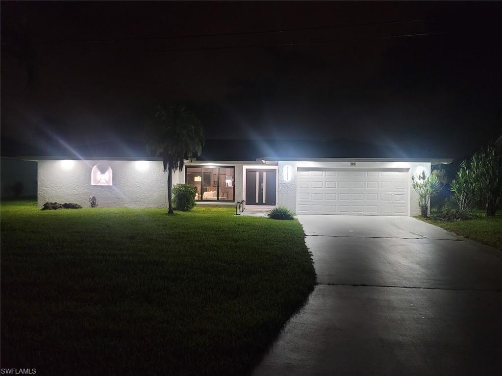 Image 4: View of front of home with driveway, a lawn, and a garage