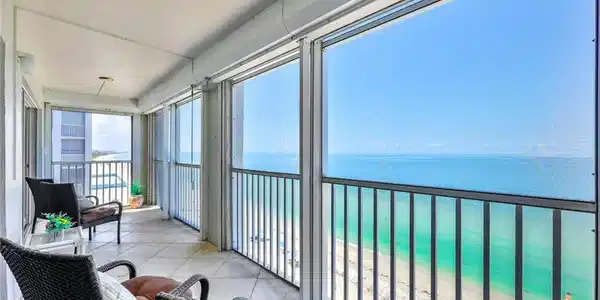 Image 2: Sunroom / solarium with a view of the beach and a water view