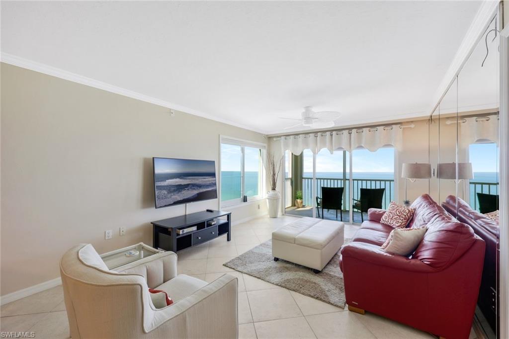 Image 3: Tiled living room with a water view, ceiling fan, and crown molding