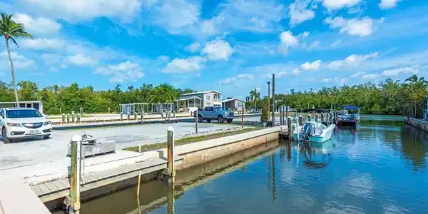 Image 4: Dock with a water view, a boat ramp, and view of wooded area