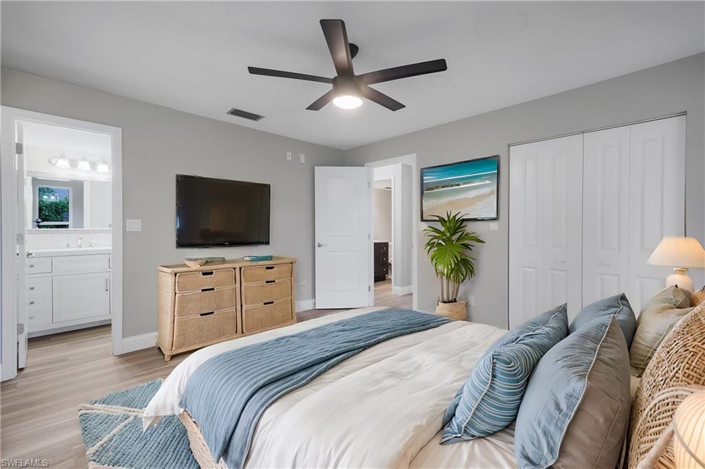 Image 3: Bedroom with connected bathroom, ceiling fan, sink, light hardwood / wood-style floors, and a closet