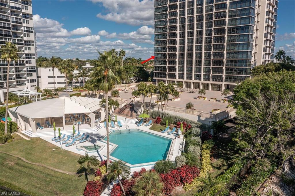 Image 3: Community pool with a patio area, a lawn, and a jacuzzi