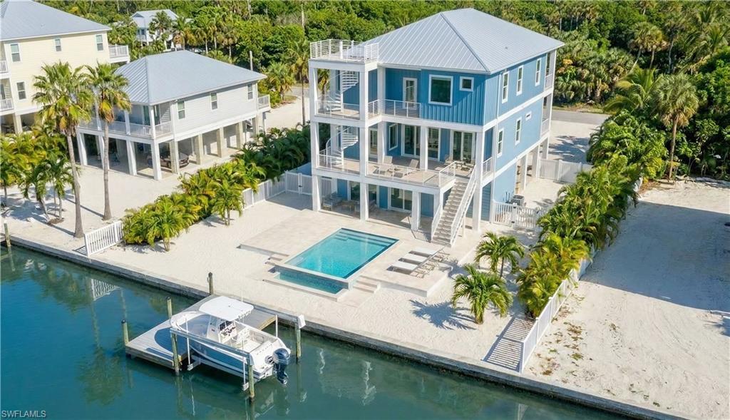 Image 1: Rear 3D rendering of house with pool area, expansive decks & multiple levels, gulf access canal - virtually enhanced