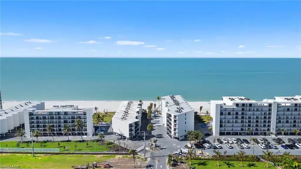 Image 1: Drone / aerial view of apartment complex and expansive coastline