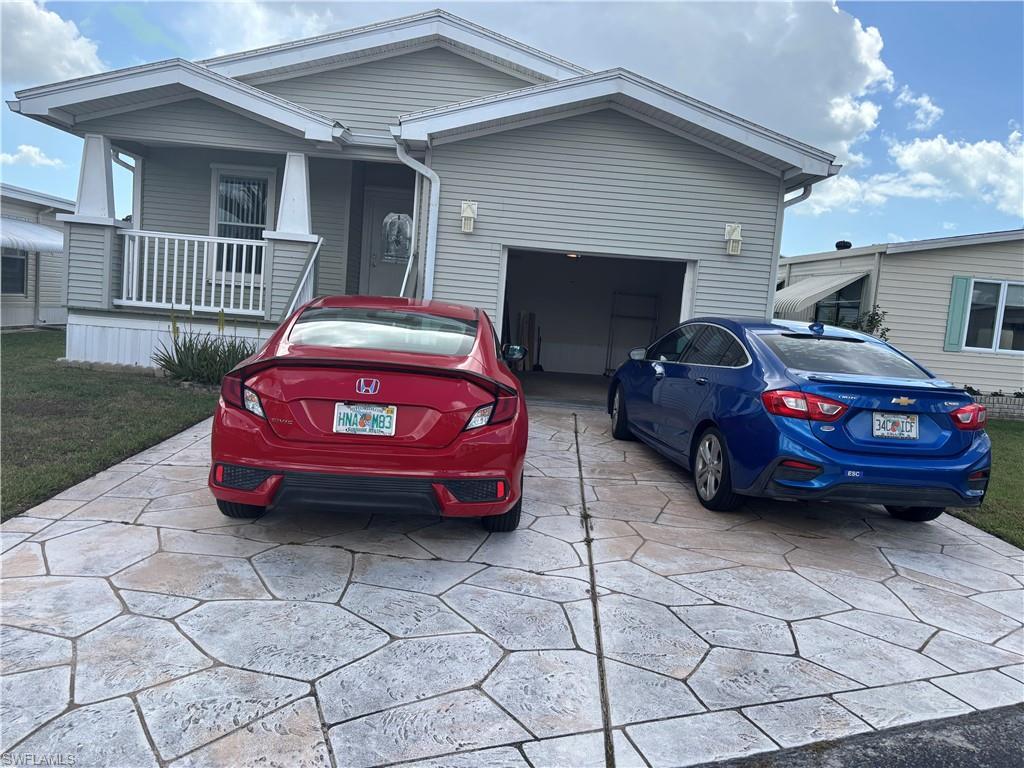 Image 4: View of front of house featuring concrete driveway, an attached garage, and a porch