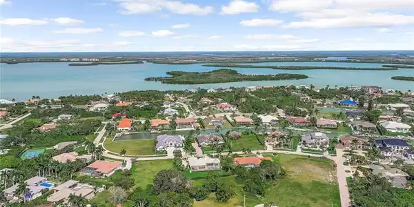 Image 4: Aerial view of residential area featuring a large body of water