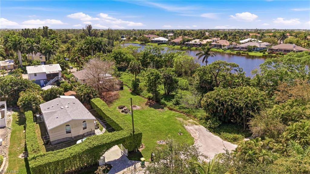 Image 4: Aerial perspective of suburban area featuring a tree filled landscape and a nearby body of water