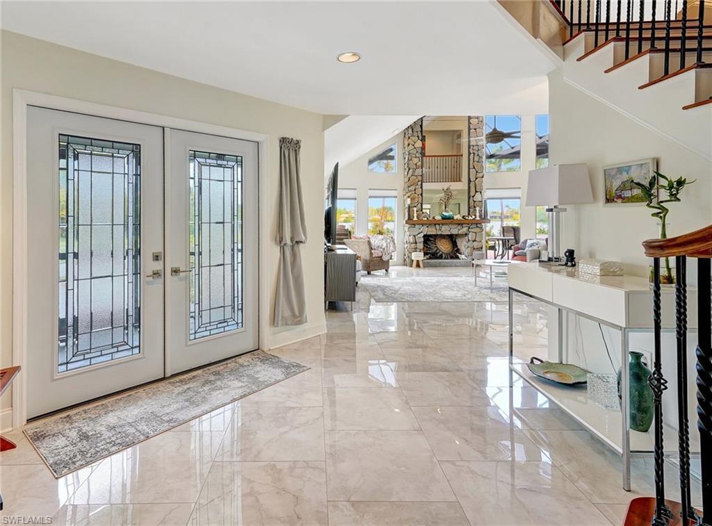 Image 3: Entrance foyer with marble finish floor, ceiling fan, a high ceiling, and french doors