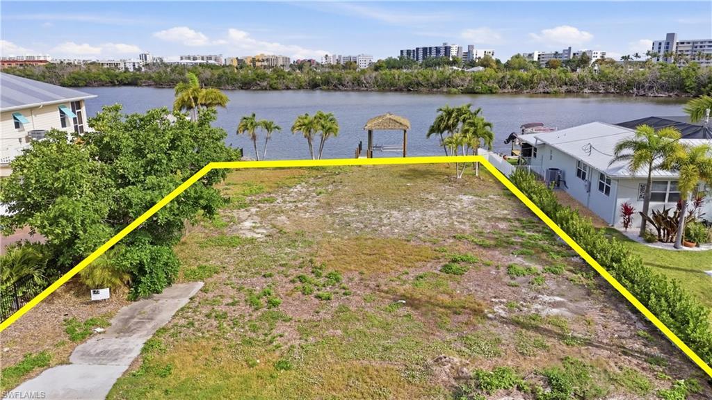 Image 3: View of urban area with property boundaries highlighted and a nearby body of water - Virtually Edited Image