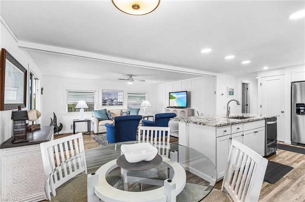 Image 3: Open-concept living space featuring wood-finish flooring throughout