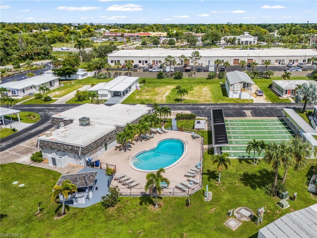 Image 4: Community amenity area featuring a swimming pool, surrounding lounge deck, and a clubhouse building with stone-finish exterior