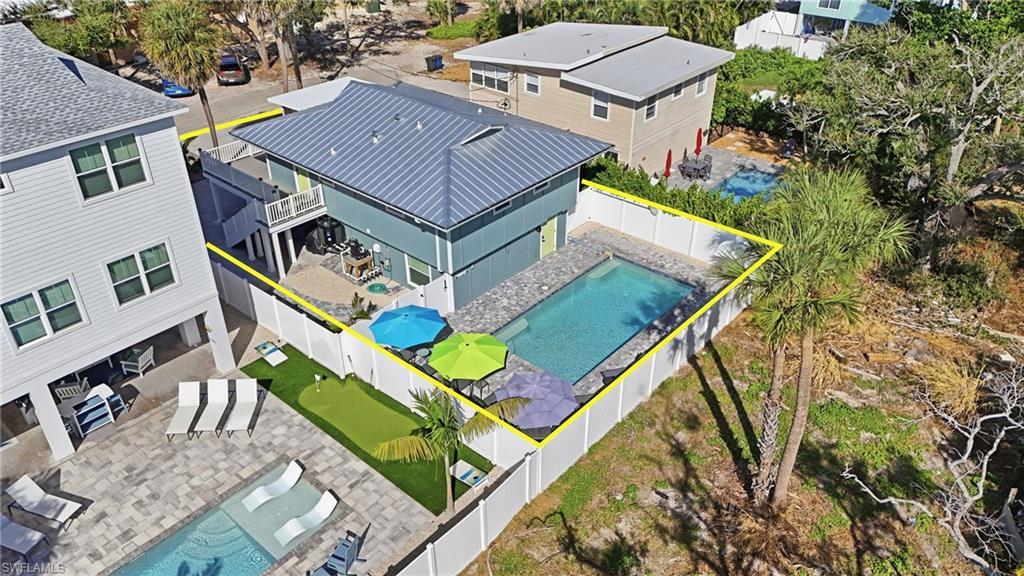 Image 4: Aerial view of rear of house and pool featuring a pool area and property boundaries highlighted- Virtually Edited Image