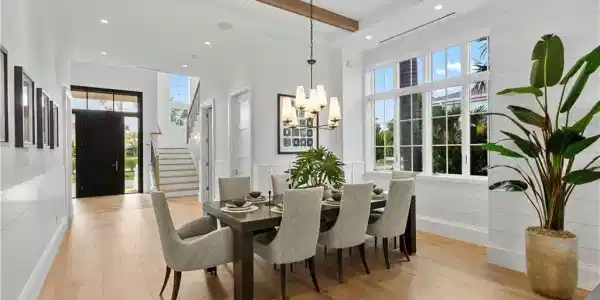 Image 4: Dining area featuring a chandelier, beam ceiling, stairway, light wood-style flooring, and plenty of natural light