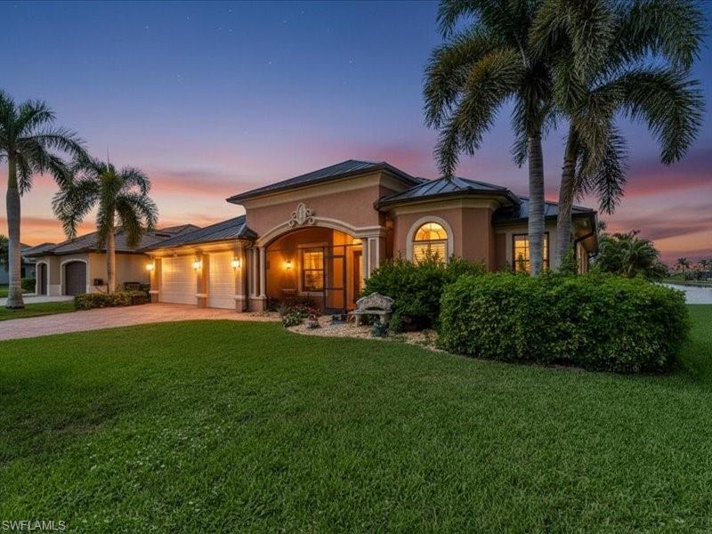 Image 2: Mediterranean / spanish-style home with a yard, driveway, stucco siding, and a garage