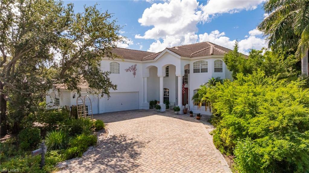 Image 3: Mediterranean / spanish home with a tiled roof, stucco siding, decorative driveway, and a garage