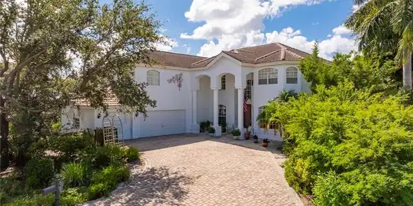 Image 3: Mediterranean / spanish home with a tiled roof, stucco siding, decorative driveway, and a garage