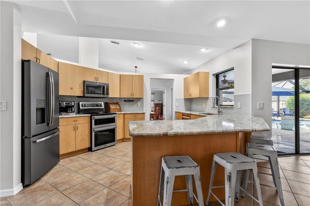 Image 4: Updated kitchen with granite, stainless appliances and breakfast bar