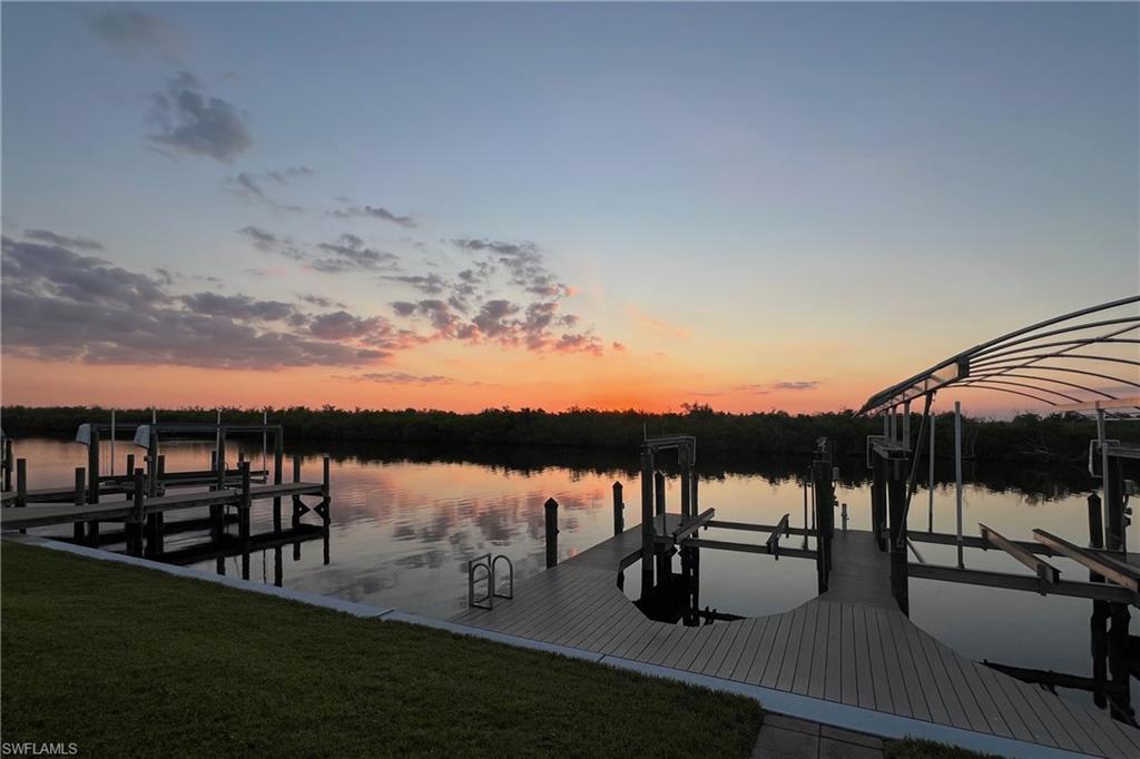 Image 3: 10000# lift and 3000# lift Dock area featuring boat lift, a yard, and a water view
