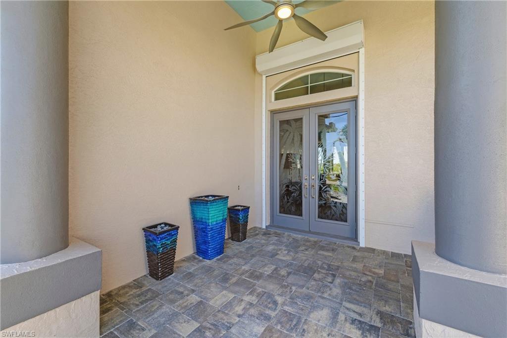Image 4: Doorway to property featuring french doors, stucco siding, and a ceiling fan