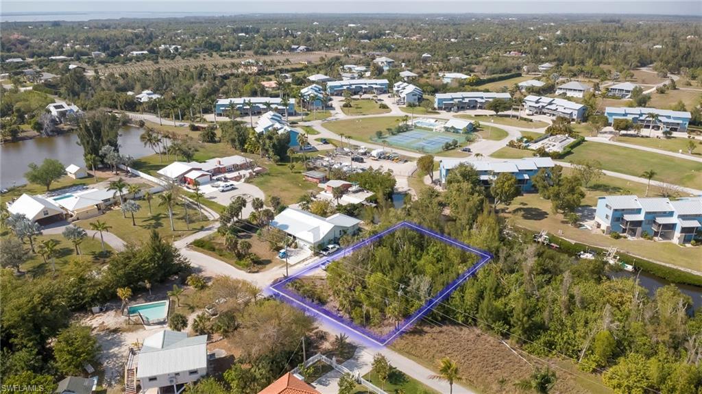 Image 2: Aerial view of residential area with property parcel outlined and a large body of water
