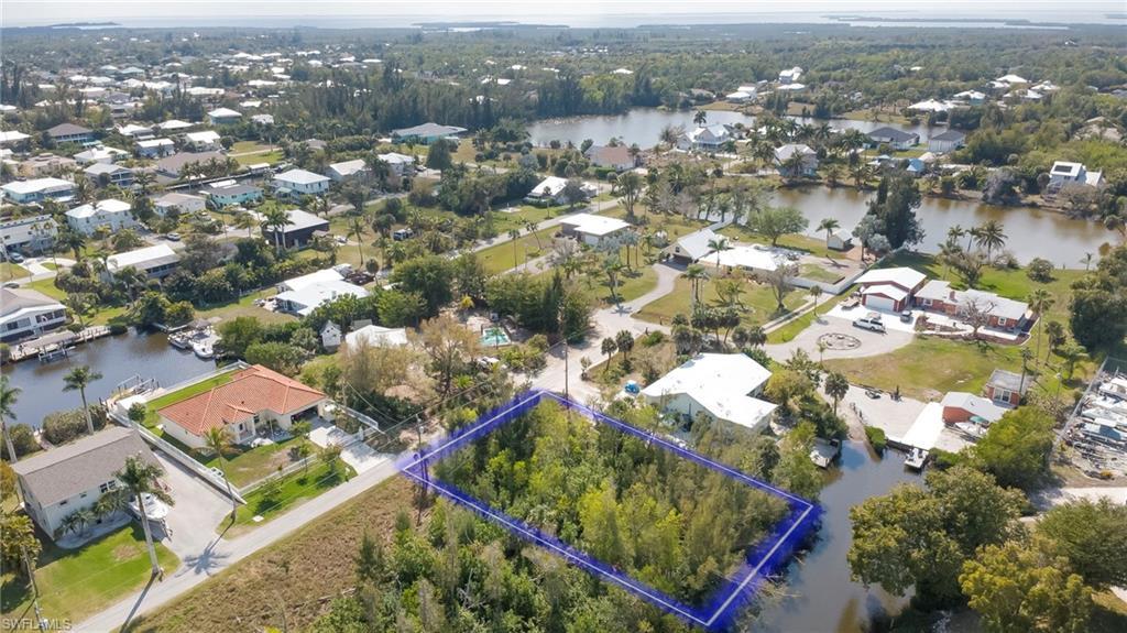 Image 4: Aerial view of residential area with property boundaries highlighted and a nearby body of water