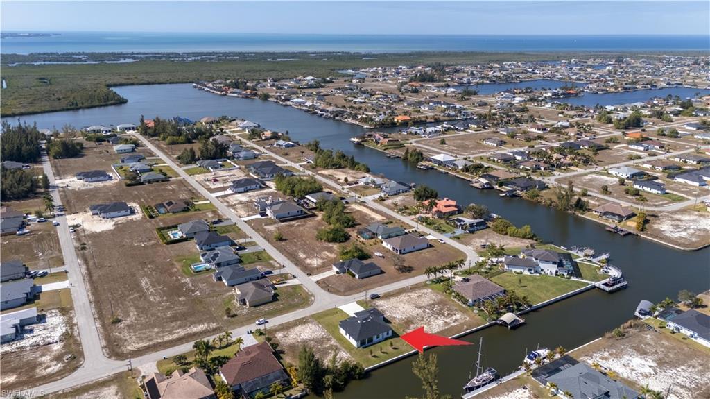 Image 2: Aerial view of property and surrounding area with nearby suburban area and a nearby body of water