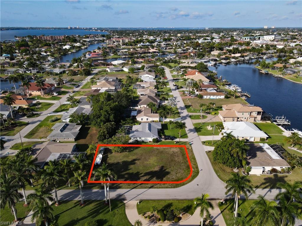 Image 1: Aerial view of residential area with property boundaries highlighted and a large body of water