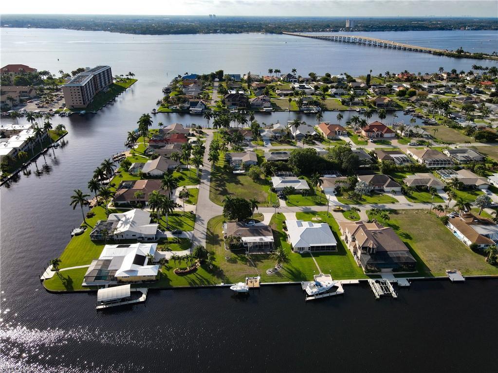 Image 2: Aerial perspective of suburban area with a large body of water and a notable bridge