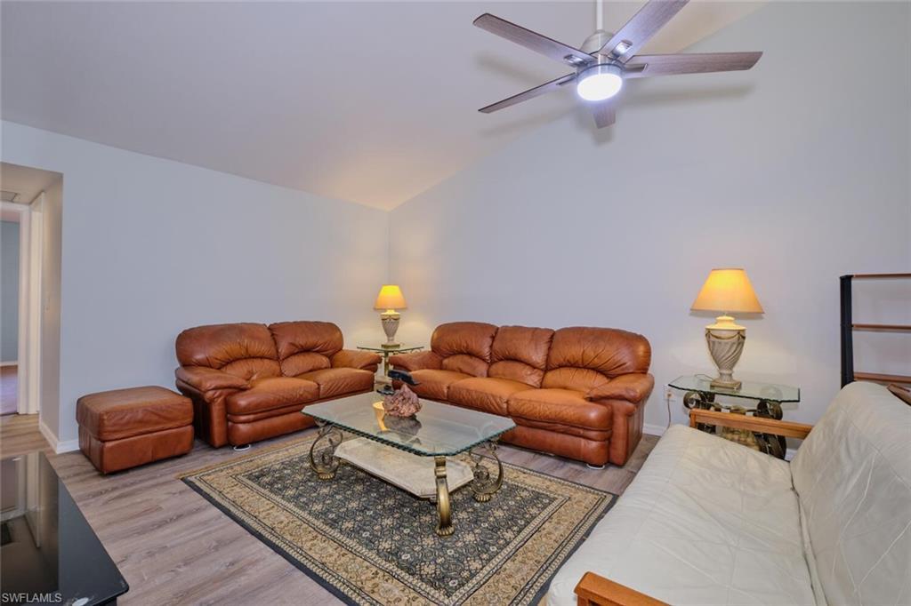 Image 3: Living area featuring wood finished floors, lofted ceiling, and a ceiling fan