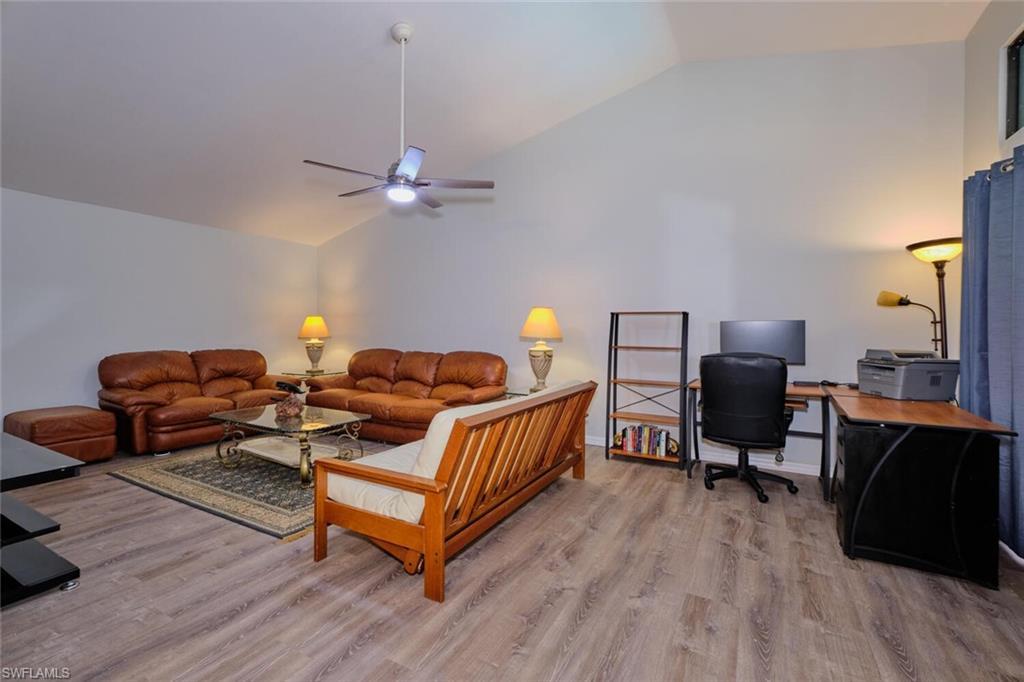 Image 4: Living room featuring an office area, vaulted ceiling, light wood-style floors, and ceiling fan