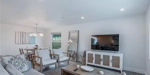 Image 2: Living area featuring a chandelier, visible vents, baseboards, and wood finished floors
