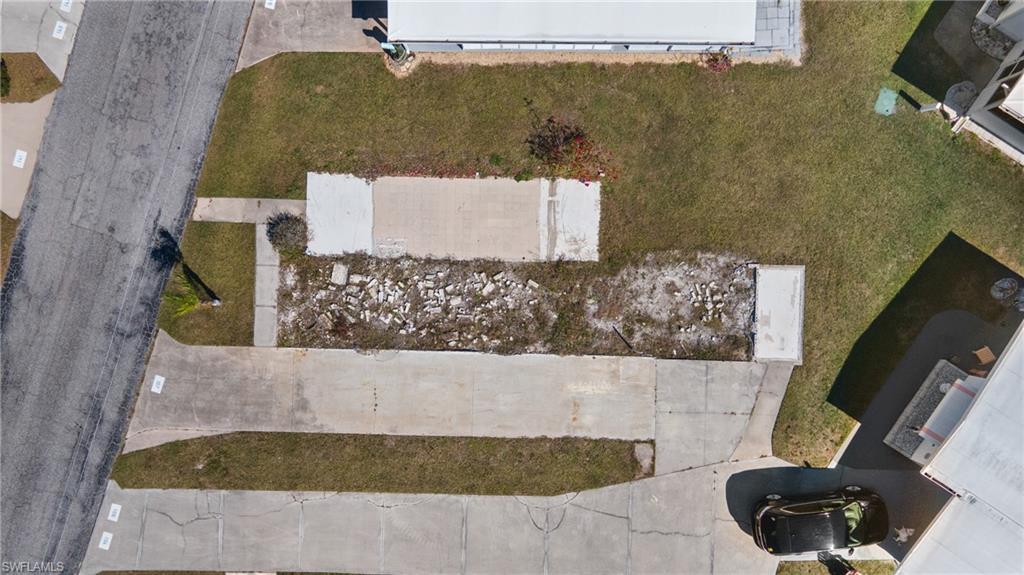 Image 2: Expansive lot featuring concrete pads, an extended driveway, and a partially cleared area