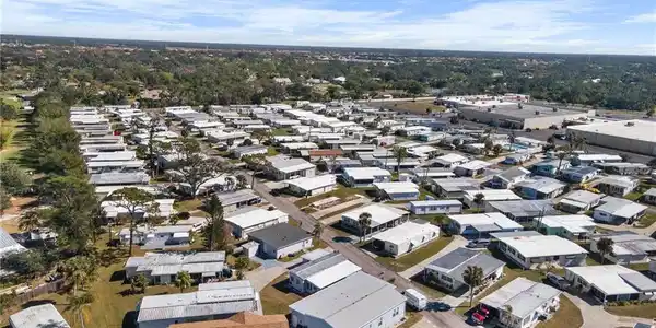 Image 3: Expansive residential community featuring numerous single-story homes, mature landscaping, and paved roads