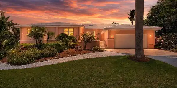 Image 3: Stunning curb appeal with lush tropical landscaping and a welcoming entry.