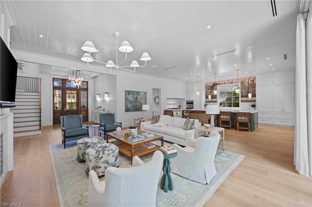 Image 1: Living room with an inviting chandelier and light hardwood / wood-style floors